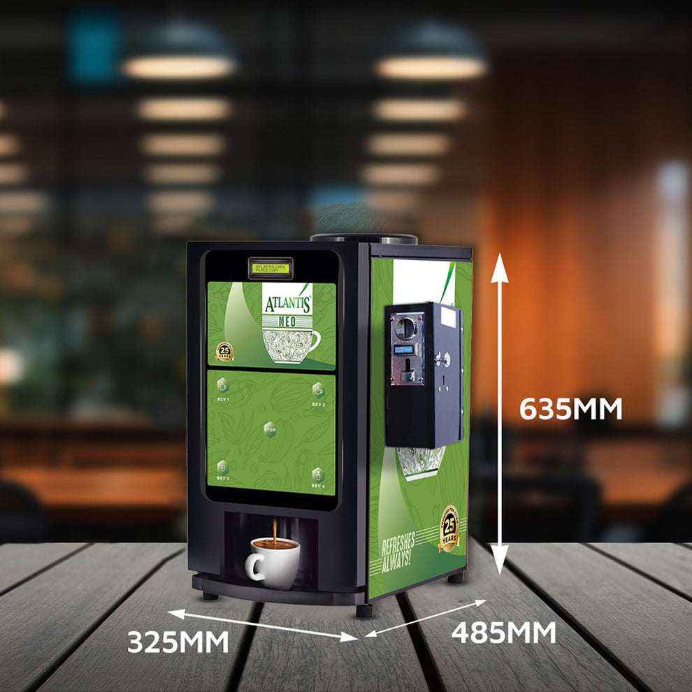 Coin operated coffee vending machine with green design and dimensions displayed on wooden surface