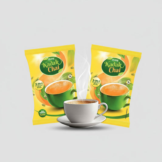 Atlantis Kadak 3-in-1 Tea premix packets with a steaming cup of prepared tea in white cup and saucer